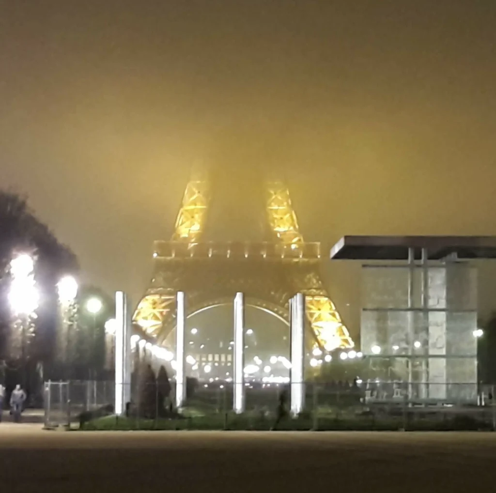 tour Eiffel illuminée par une nuit de brouillard